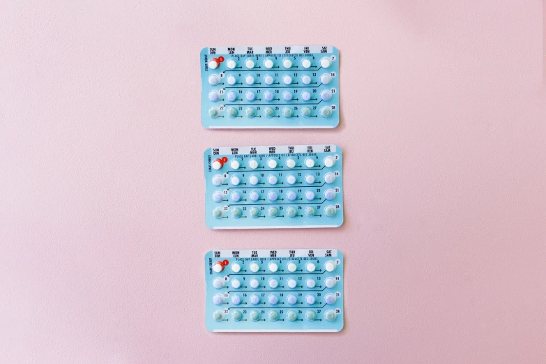 a pink wall with some blue plastic objects sitting on it