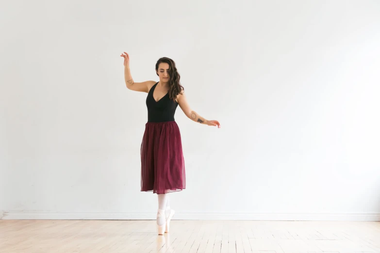 a person in black shirt and purple skirt on a hardwood floor