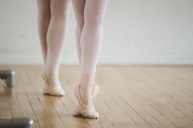 a woman in a ballet costume stepping on a wooden floor