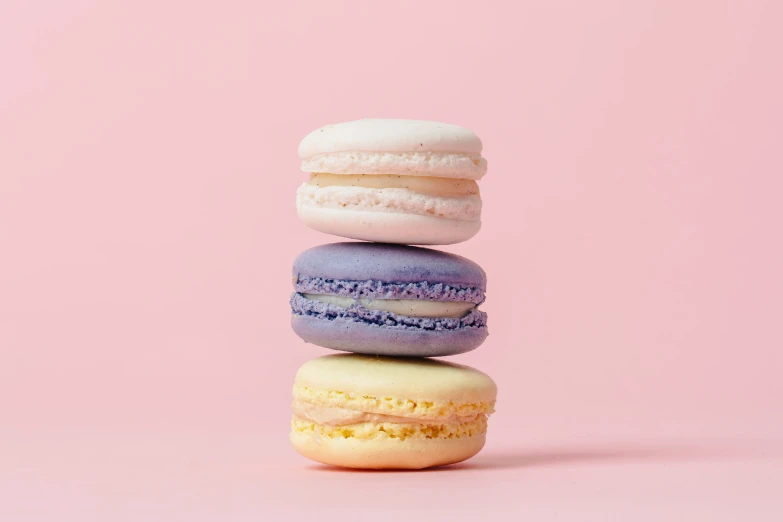 four macaroons are arranged together in the shape of five in different colors