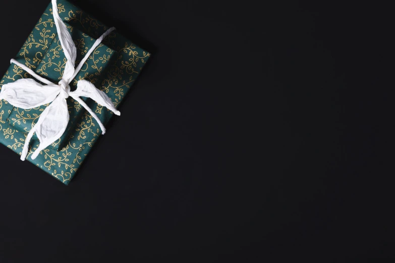 a wrapping paper wrapped in green and white with a bow