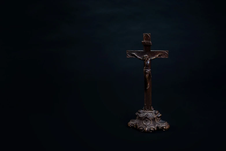 an old fashioned cross in the dark, with no light on it