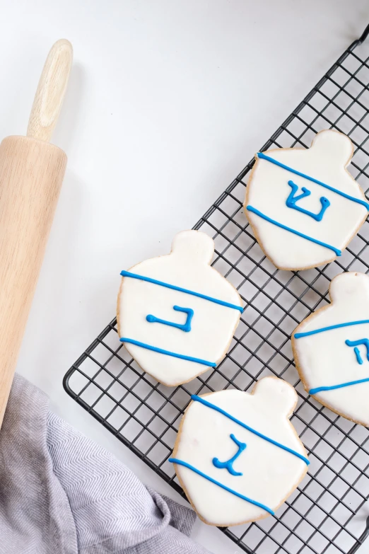 several decorated cookies on cooling racks with a wooden handle