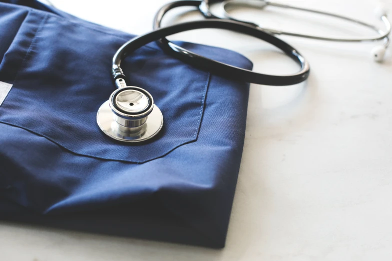 close up of medical stethoscope, pocket knife and uniform