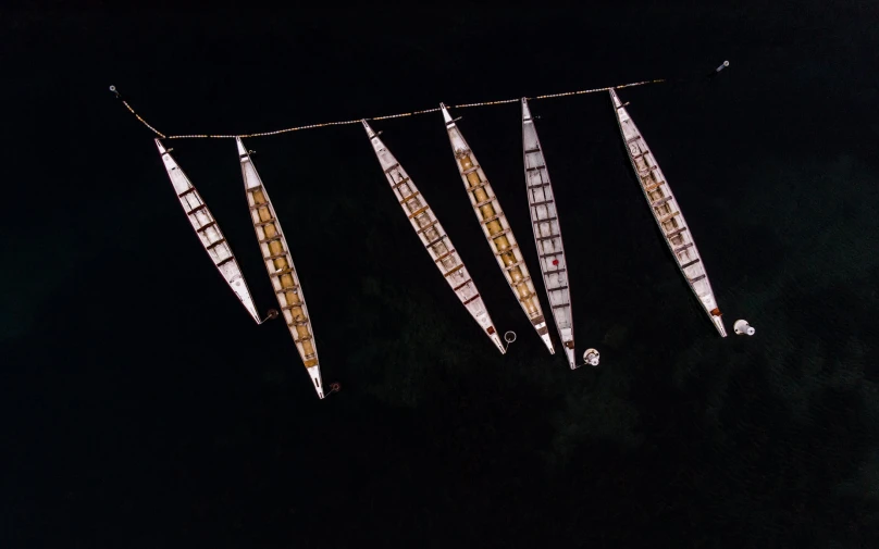 three sets of boats on a rope in the dark