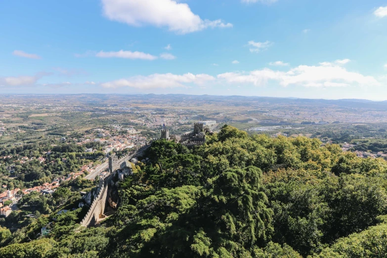 a scenic view of a city and mountains on a sunny day