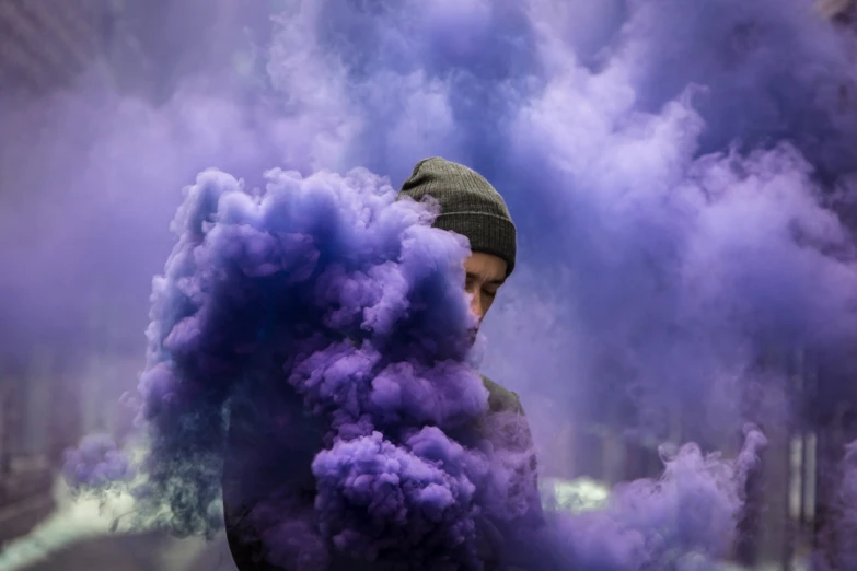 a man standing in front of some purple smoke