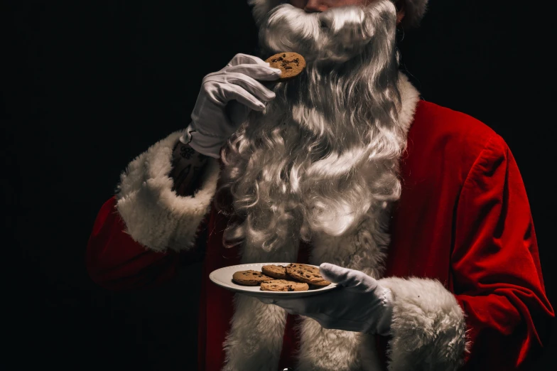 santa eating a cookie from a white plate