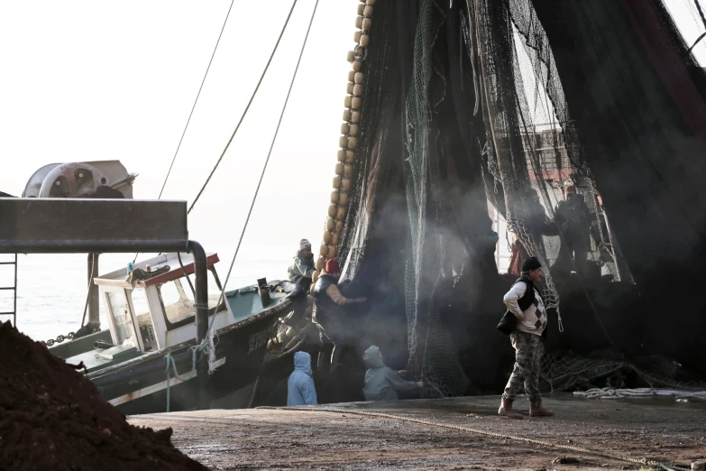 a fishing boat near another boat with it's sails down