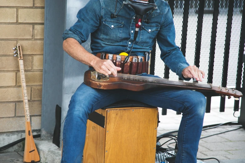 a man is sitting on a stool playing guitar