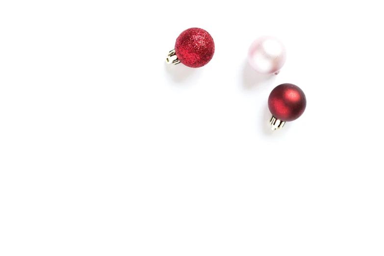 two red and white christmas balls placed side by side