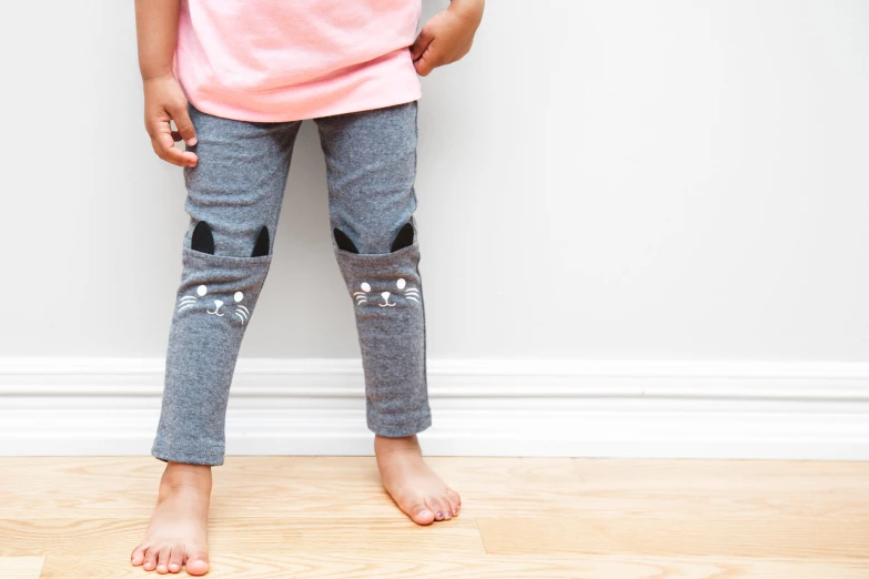 a little girl with her legs out wearing ripped jeans