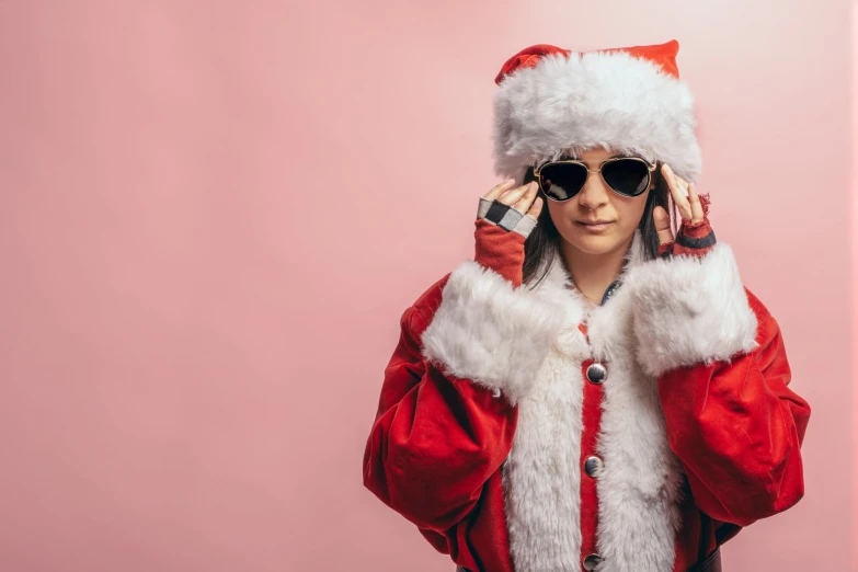 a woman in a santa hat is holding her hands to her ears