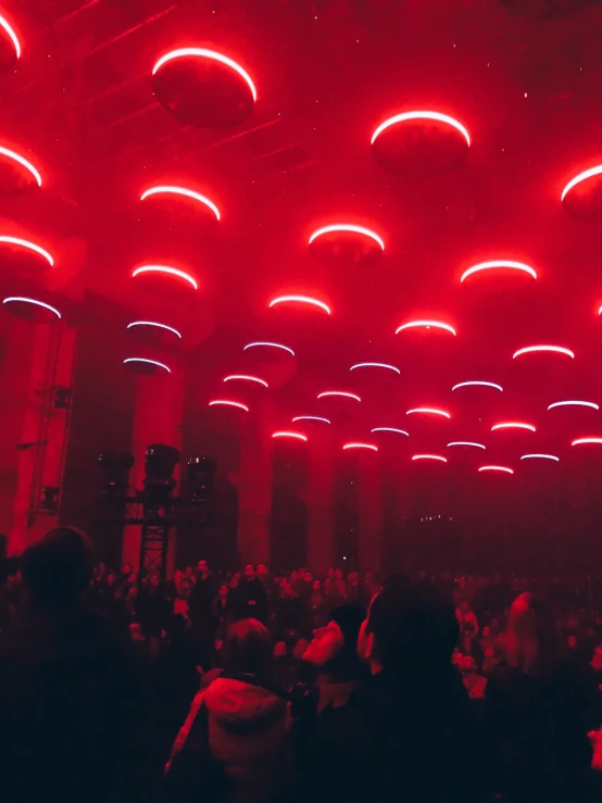 a large audience is looking up at a very colorful stage