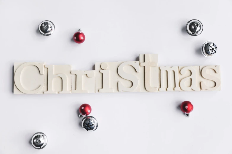 a white christmas sign surrounded by lots of small ornaments