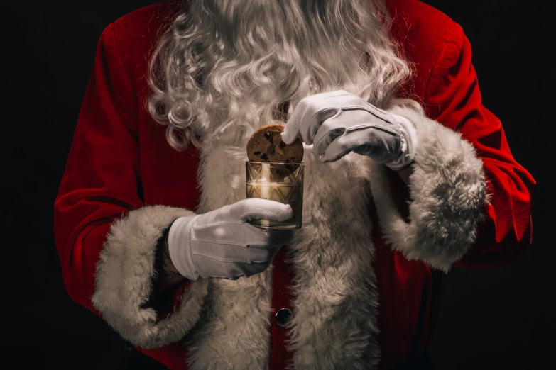 a man dressed in a santa outfit holding a lit candle