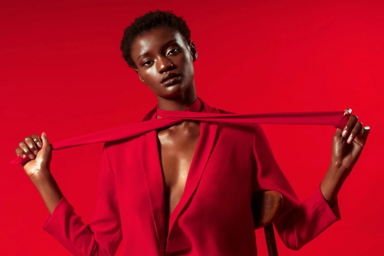 a woman wearing a red shirt and holding onto a tie