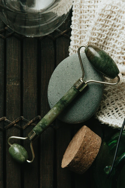 a green stone, wire and fishing lure on wooden board