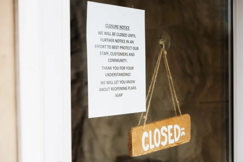 close up view of a closed sign hanging from a door