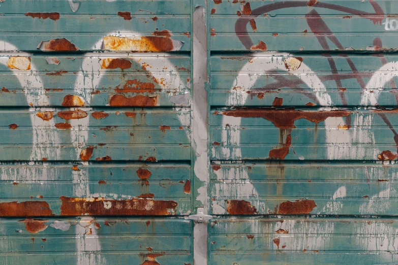 an old, rusty metal wall is painted blue with brown streaks