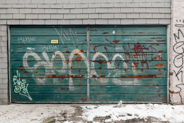 a rusty garage door with graffiti and numbers on it