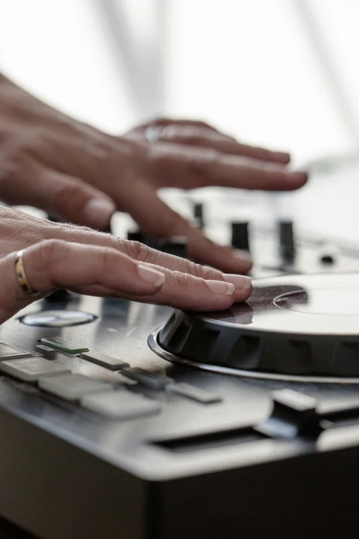 hands playing music on a turntable in a black and white po