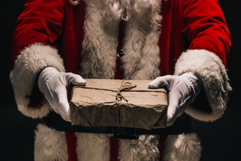 a man in white gloves holding a cardboard present