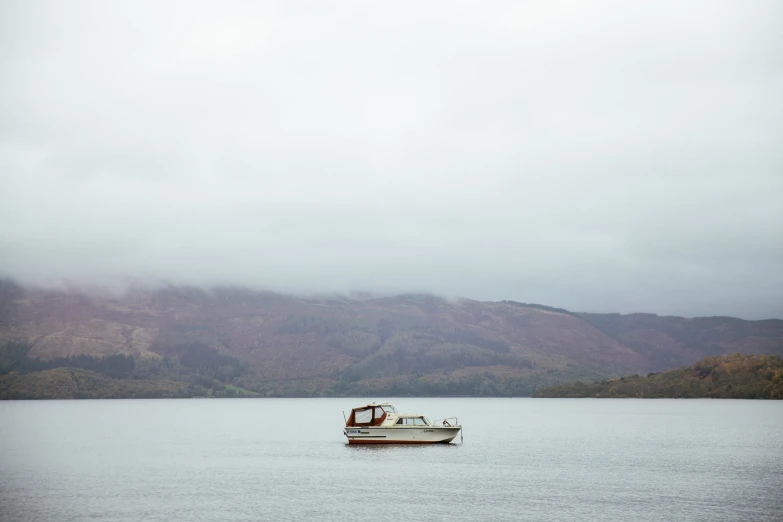 there is a boat out on the water with mountains in the background