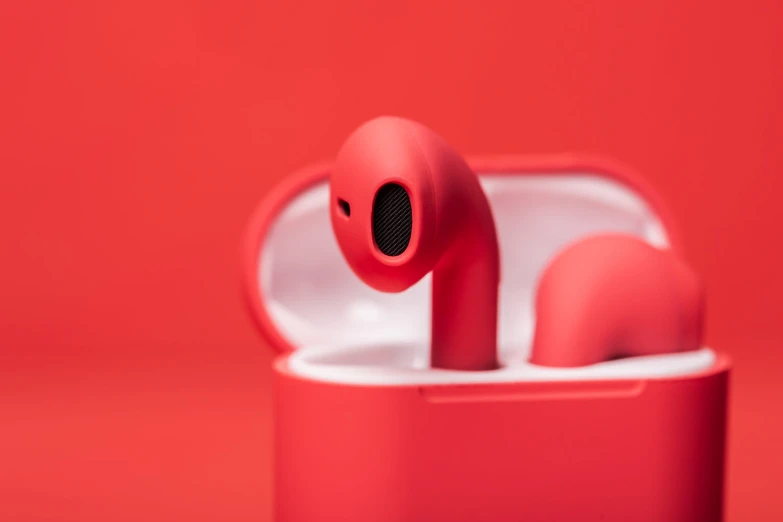 a pair of red earbuds sitting inside of an opened container