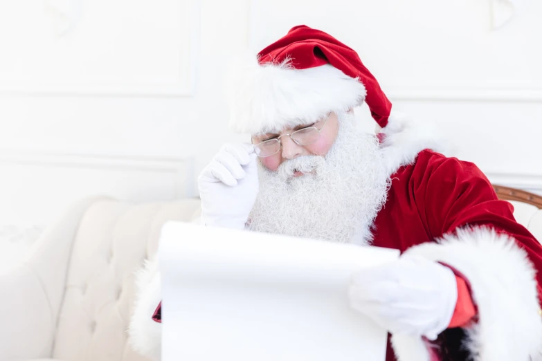 santa claus sitting on a couch using his laptop