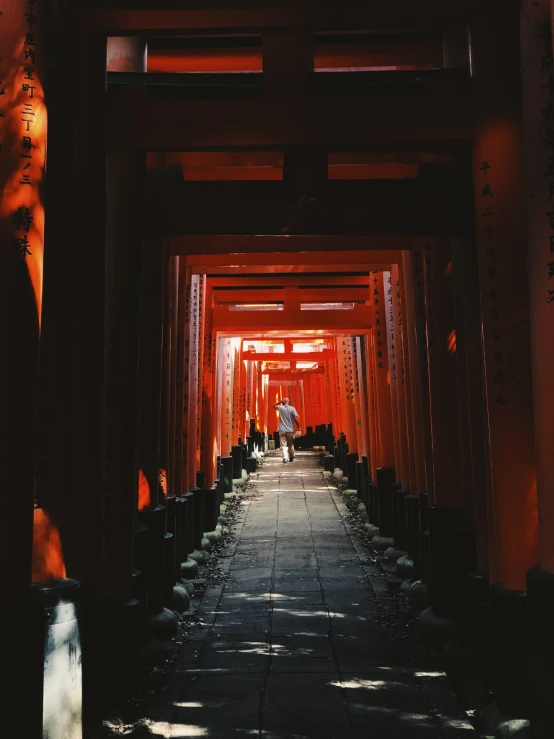 a man walking down an open walkway in a temple