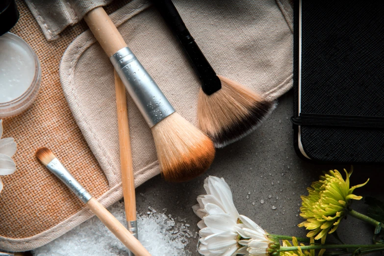 cosmetics and flowers on a towel with a bottle