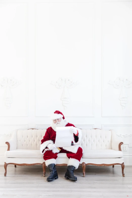 santa claus sitting on a sofa with his legs crossed