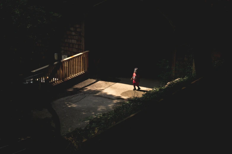 a person walking on the sidewalk at night