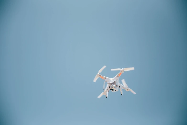 a remote controlled white flying in a blue sky