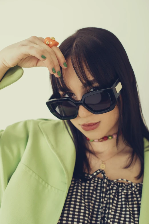 the woman is wearing sunglasses and holding onto her hair