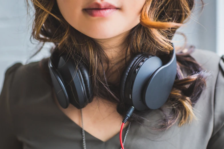 a woman wearing headphones has her hands on the side