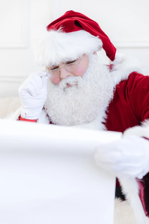 a man wearing a santa claus outfit is looking at soing on the table