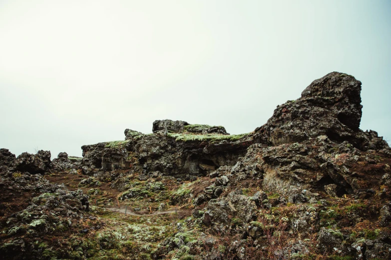 two large rocks stand on top of a rocky hill