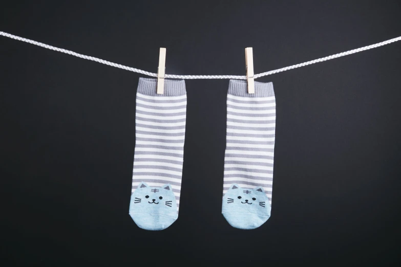 a pair of baby socks hung on a washing line