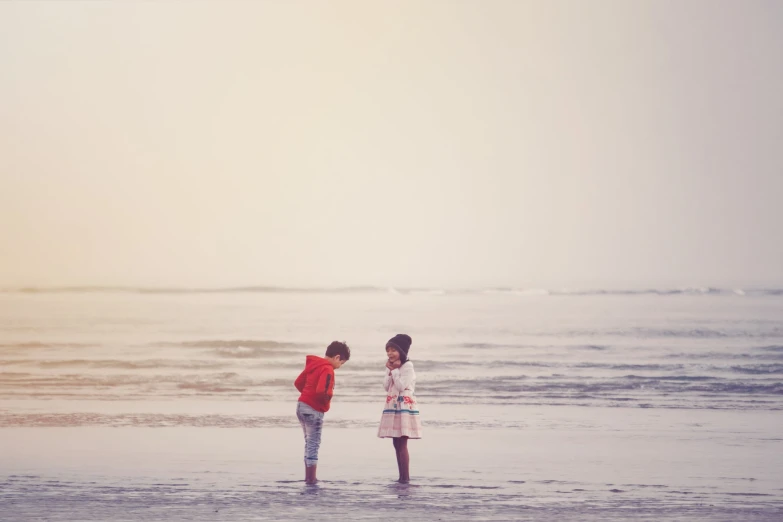 two s standing in the shallow waters of the ocean