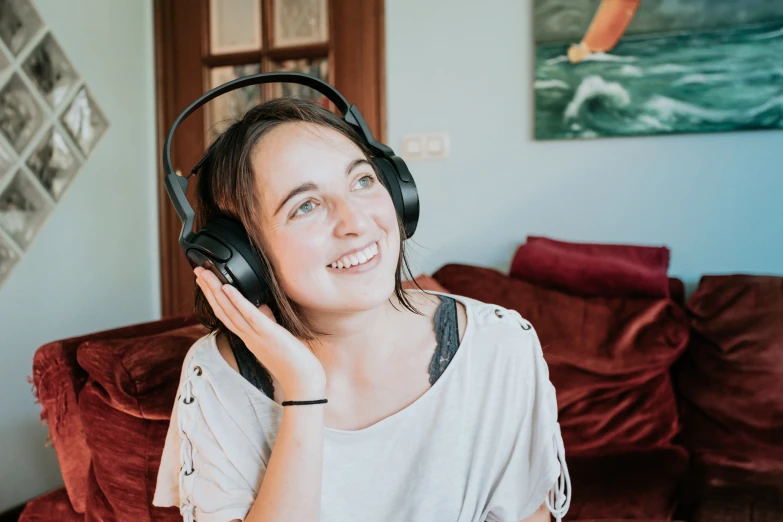 a woman in headphones, smiling and looking up at the camera