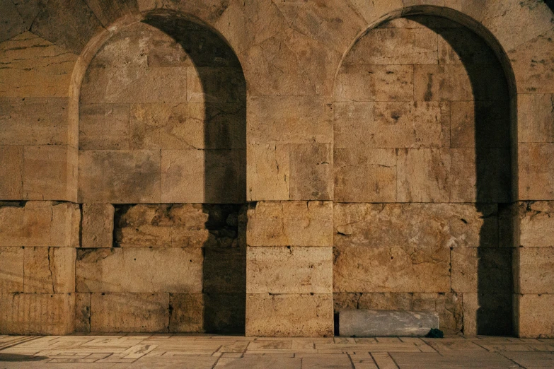 two stone archeds over a bench in an old stone building