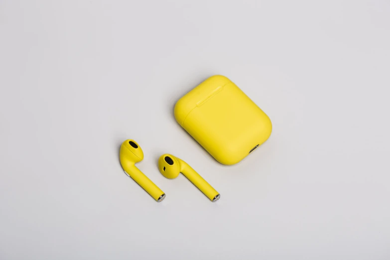 a yellow earpiece is set next to a case