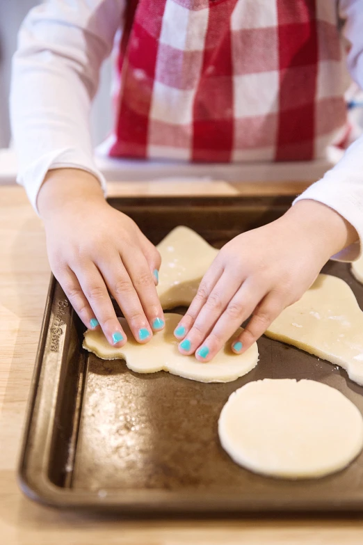 a person is preparing dough on a baking sheet