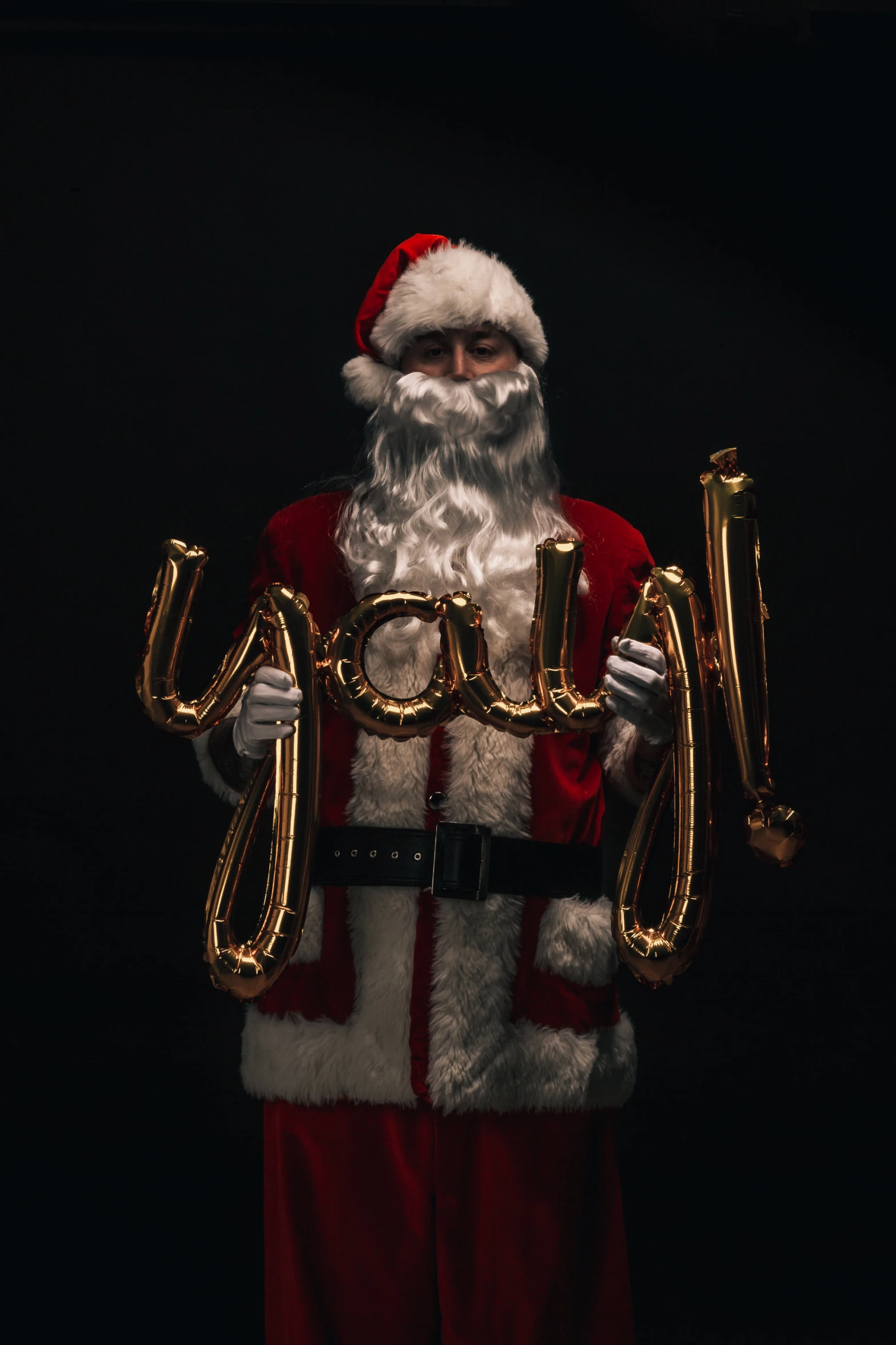a santa clause holding a bag and letters spelling joy
