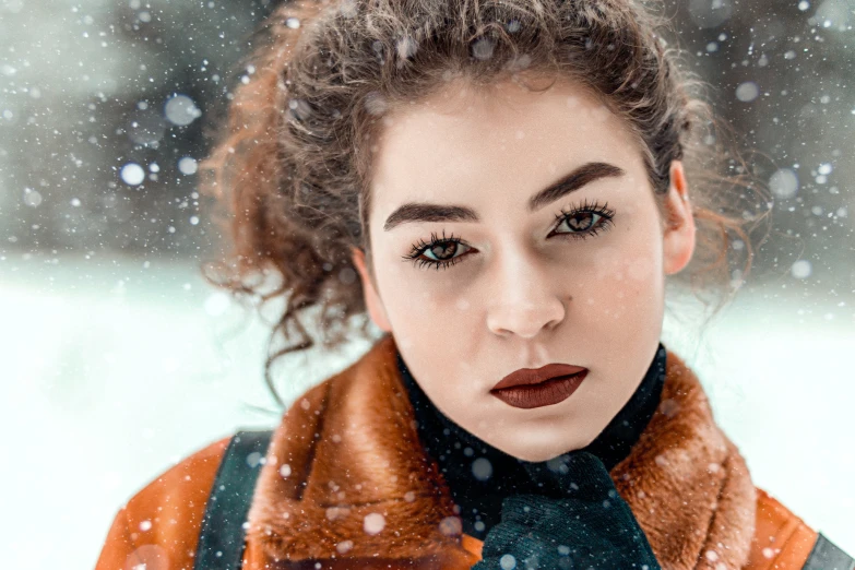 a woman with dark makeup in a brown jacket