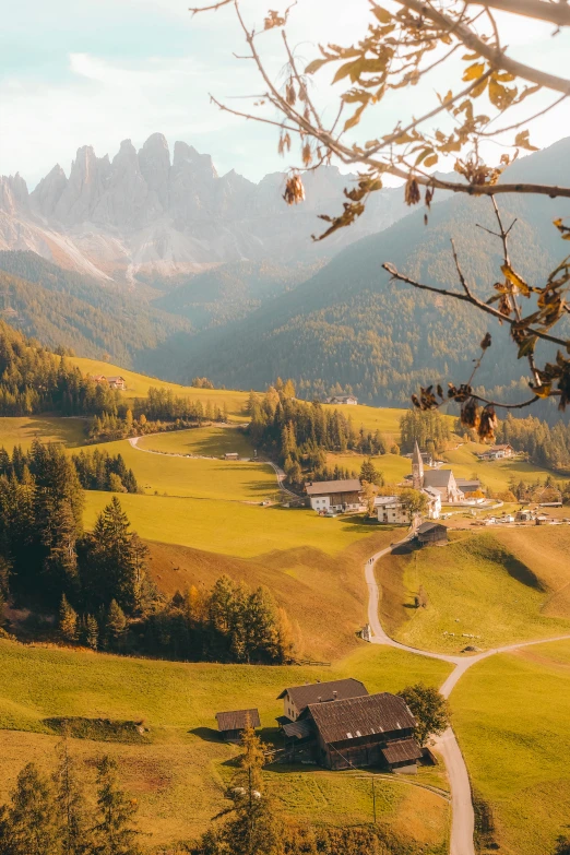 an aerial view of a countryside with a house and mountain range in the background