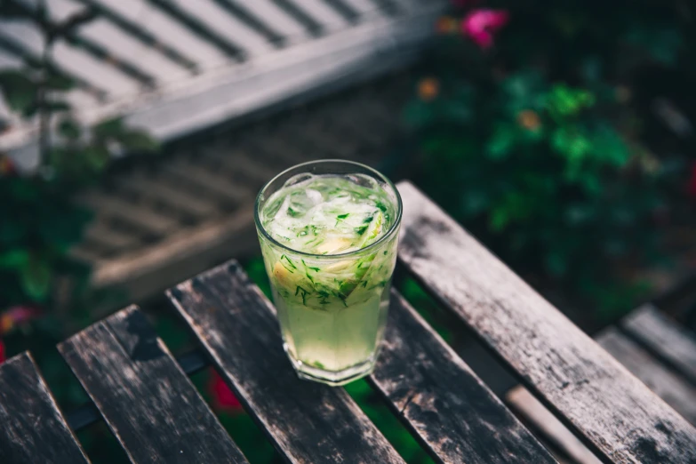 a cup of liquid sitting on top of a wooden table