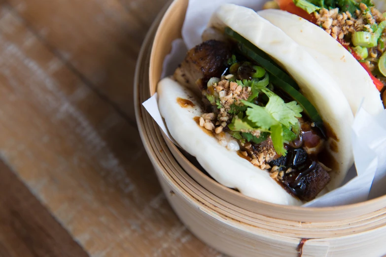 two buns with different types of food in a basket